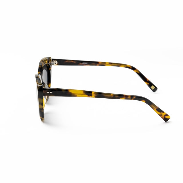 Lunettes femme en acétate écaille jaune, branches larges, verres teintés gris foncé