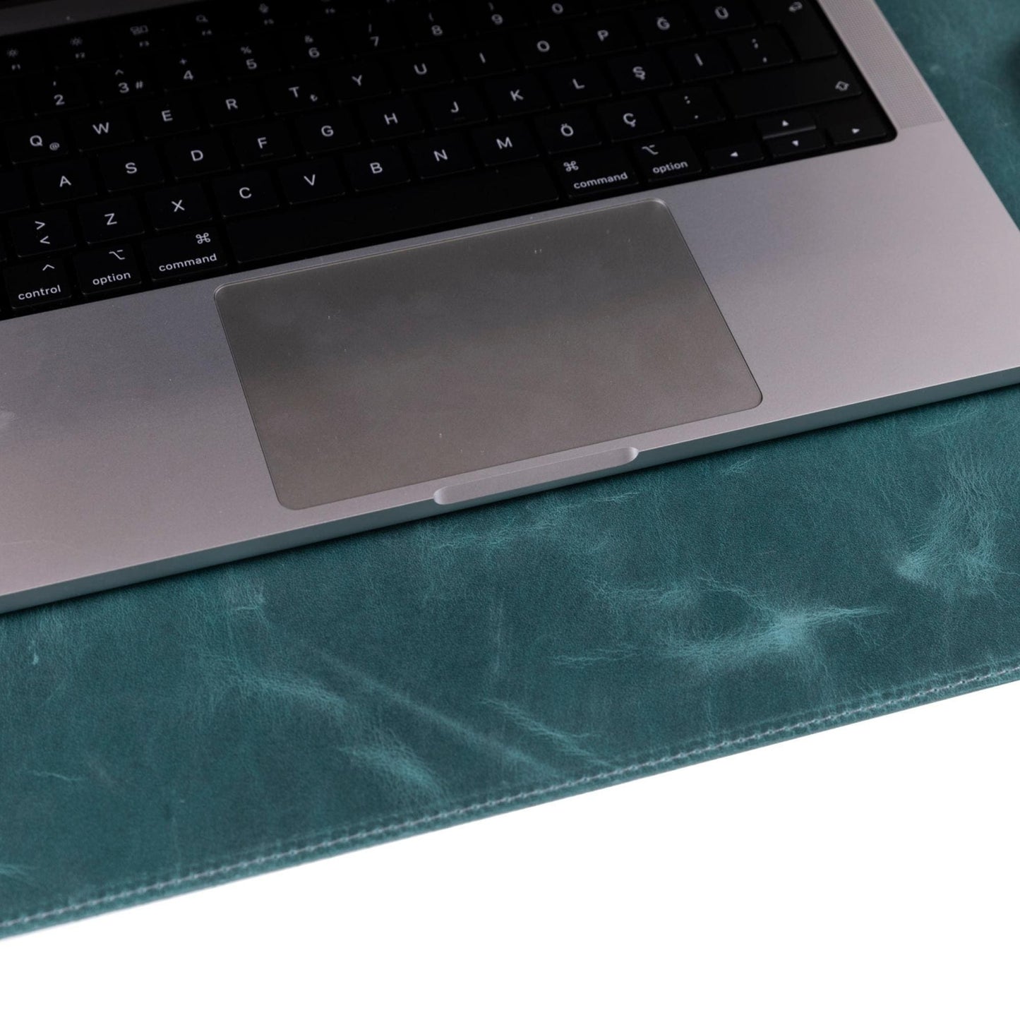 Sous-main en cuir vert bleuté, vue rapprochée, surface texturée et bord cousu