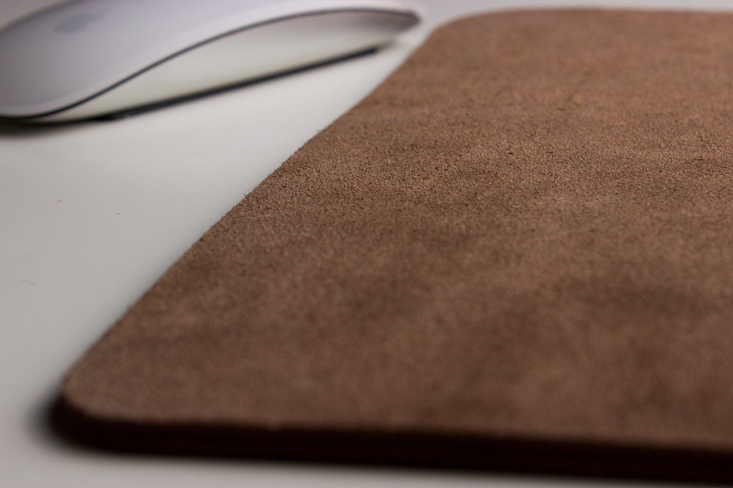 Tapis de souris en cuir brun : texture de surface et bordures visibles, logo non visible.