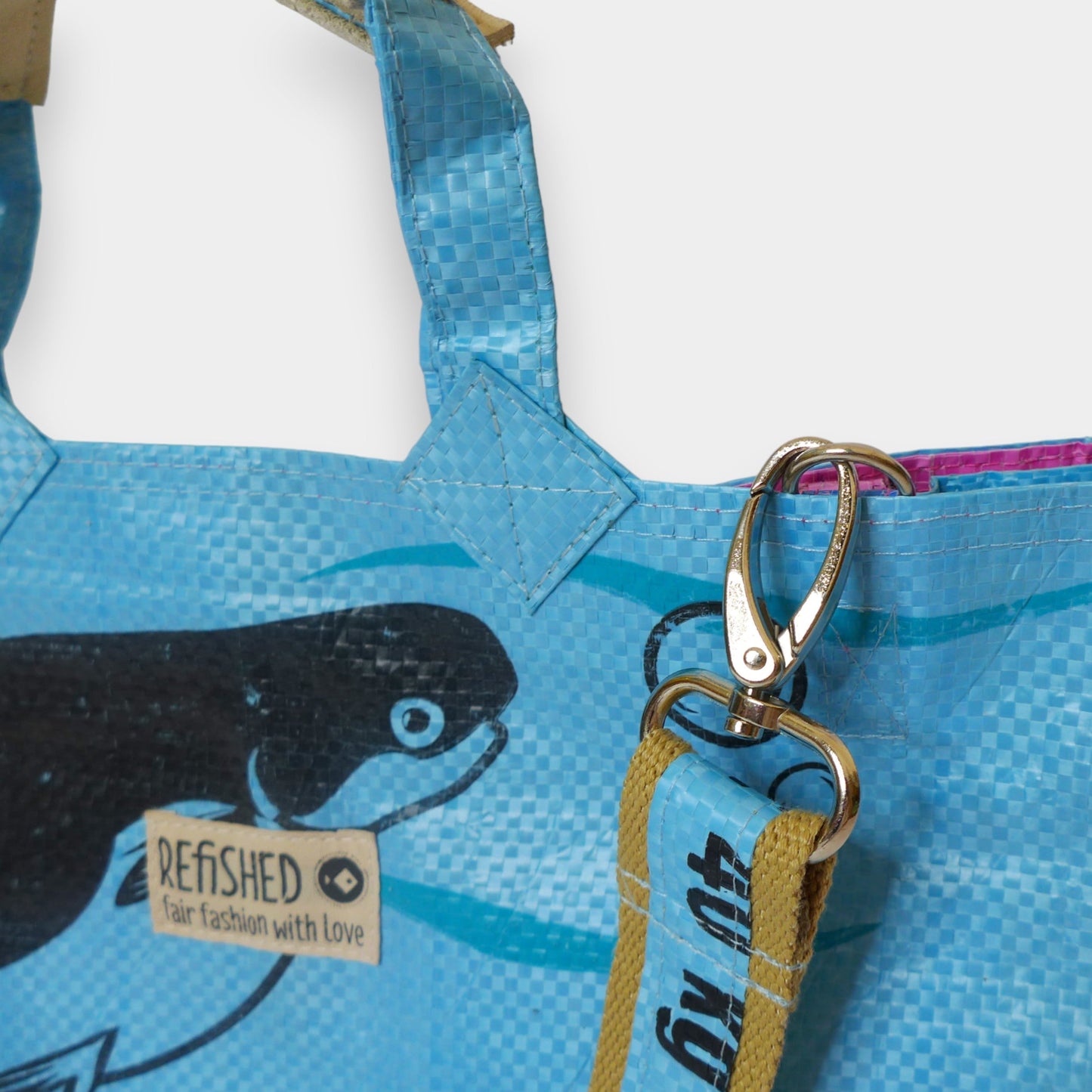 Sac bleu clair, motif oiseau noir et étiquette 'Refished'