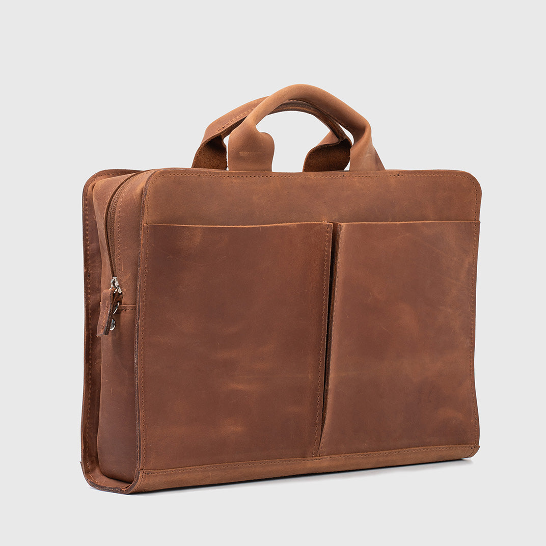 Sac d’ordinateur en cuir cognac avec poche avant, zip latéral, anses hautes.